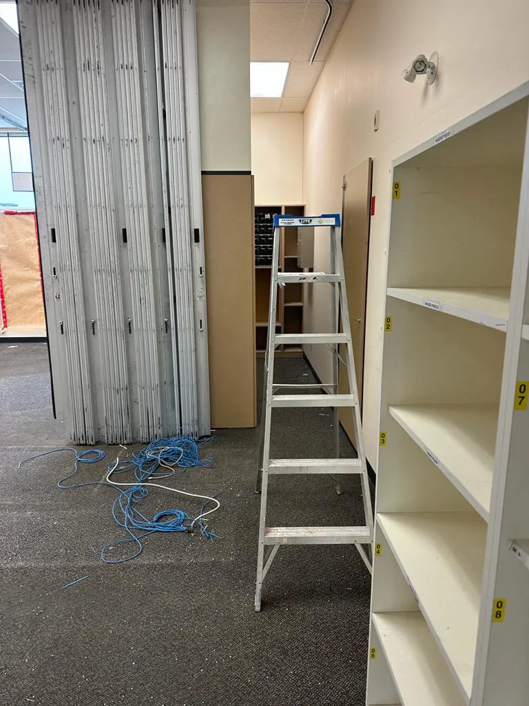 step ladder standing next to wall next to some empty shelves